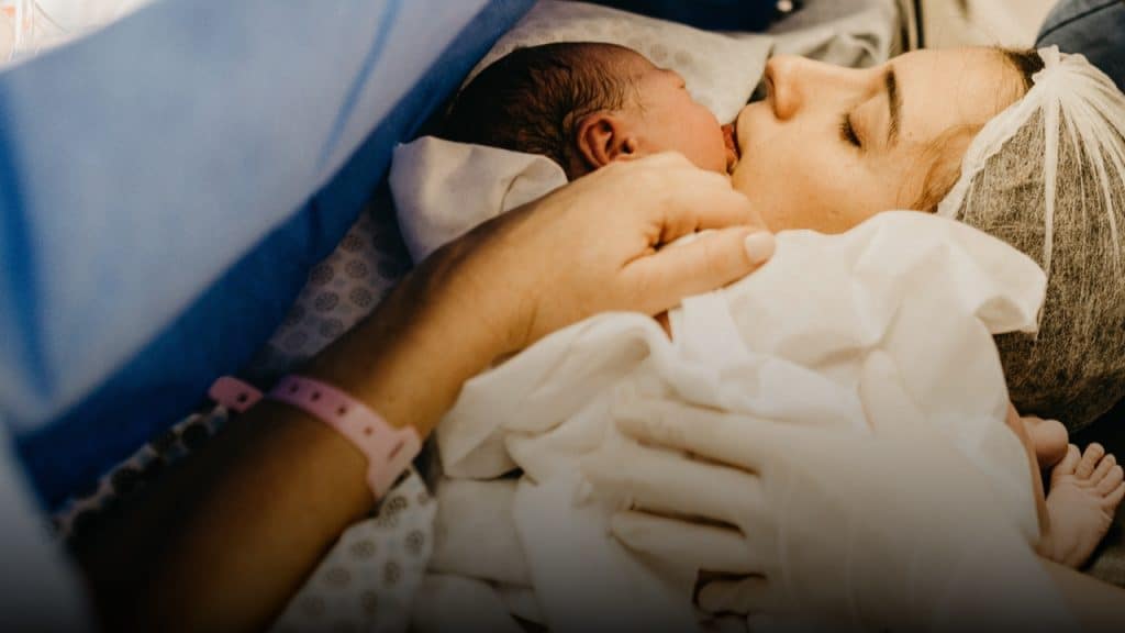 Mother holding baby after caesarean birth