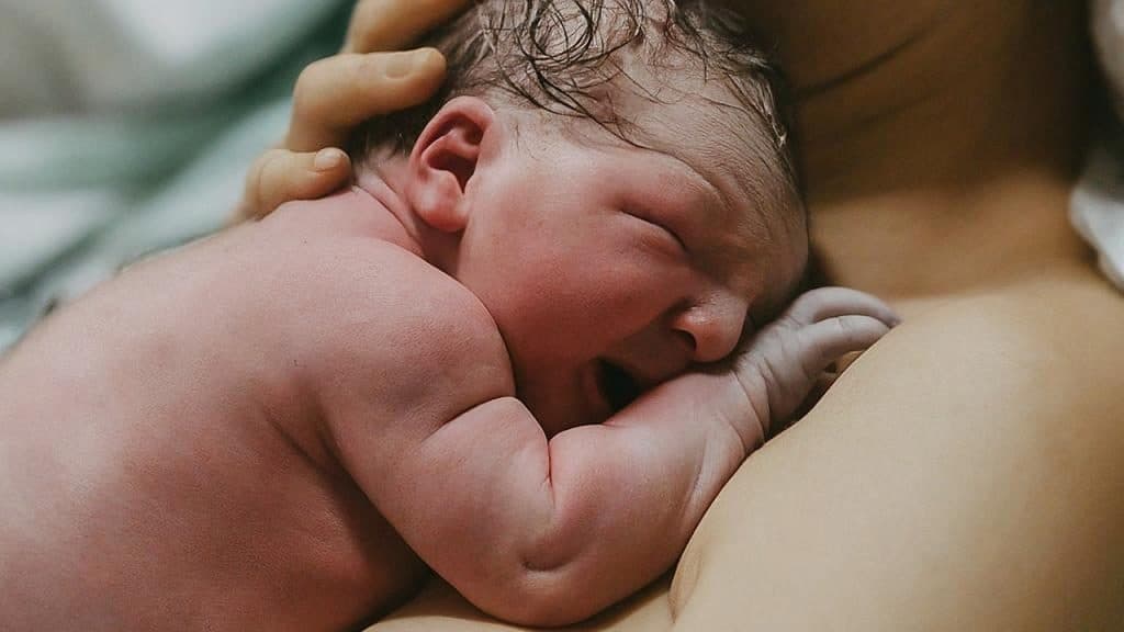 Newborn baby on the mums shoulder